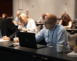 attendee at desk with computer writing in a breakout room