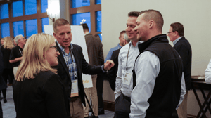 group of attendees standing in circle talking strategy 