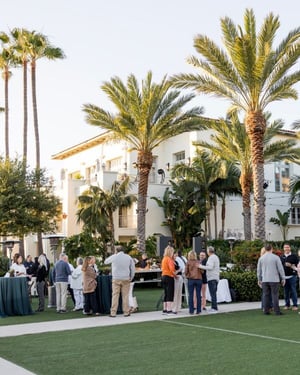 attendees outside networking around with palm trees