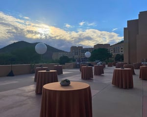 cocktail hour round table set up ourside for a networking even with mountains and sunset in background