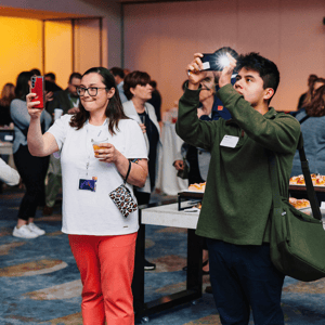 two event attendees taking photos during a conference