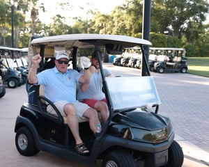 two golfers in golf cart cheering before round