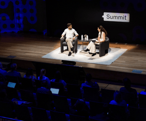 two people giving a presentation on stage during a user conference